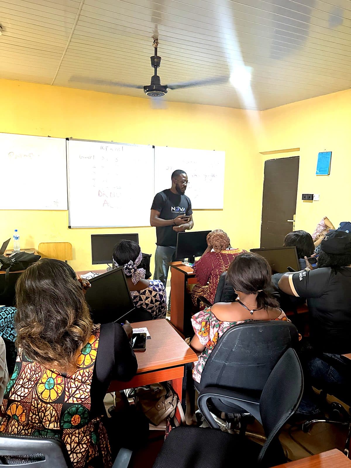 A Nova instructor teaching a cohort in front of whiteboards at a training session